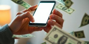 Person holding phone, money floating around.